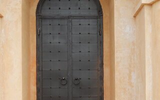 двустворчатая арочная дверь в храм с декоративной ковкой